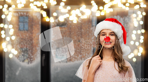 Image of happy teenage girl in santa hat on christmas