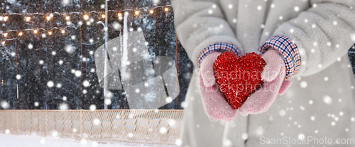 Image of close up of little girl holding heart in winter