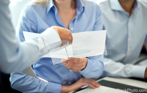 Image of happy business team with papers meeting at office