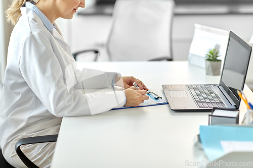 Image of doctor with laptop and medical report at hospital