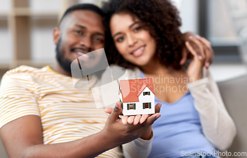 Image of happy couple with house model moving to new home