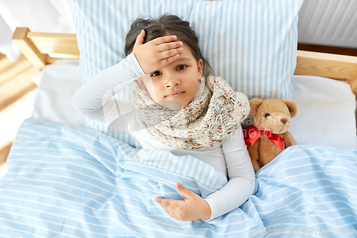 Image of sick girl lying in bed at home