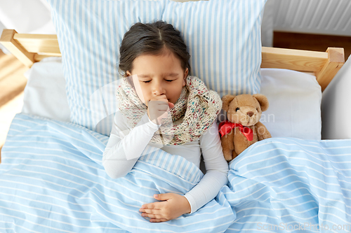 Image of sick coughing girl lying in bed at home