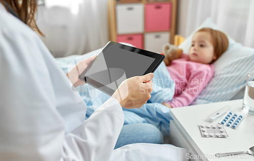 Image of doctor with tablet computer and sick girl in bed