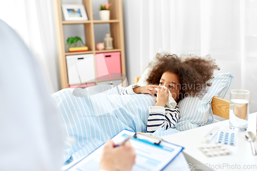 Image of doctor with clipboard and sick girl in bed at home