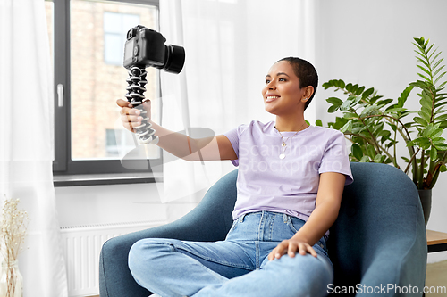 Image of female blogger with camera video blogging at home
