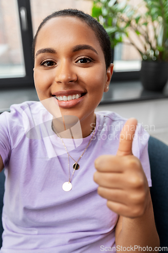 Image of happy african american woman taking selfie at home