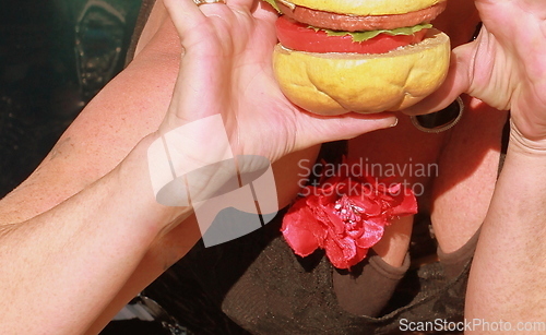 Image of Female eating a hamburger.
