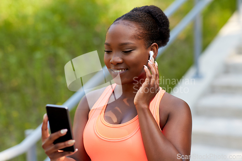 Image of african american woman with earphones and phone