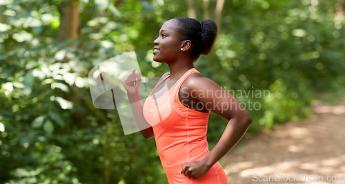 Image of young african american woman running in forest