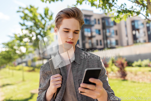 Image of teenage student boy with phone and bag in city