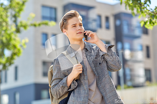Image of teenage student boy calling on smartphone in city