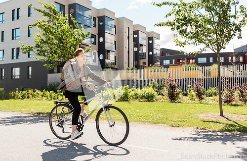 Image of young man riding bicycle on city street