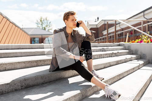 Image of teenage boy calling on smartphone in city