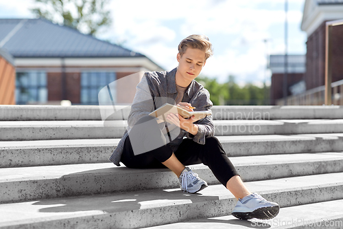 Image of young man with notebook or sketchbook in city