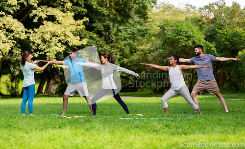 Image of group of people doing yoga at summer park