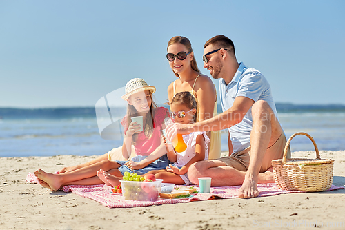 Image of happy family having picnic on summer beach