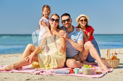 Image of happy family having picnic on summer beach