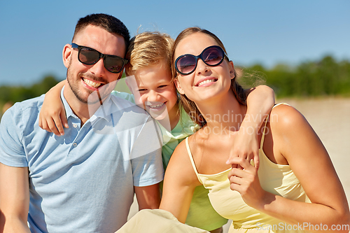 Image of happy family hugging on summer beach