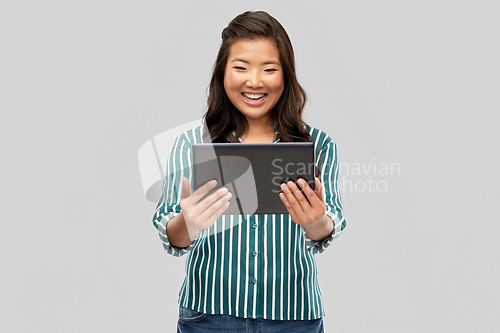 Image of happy asian woman using tablet computer