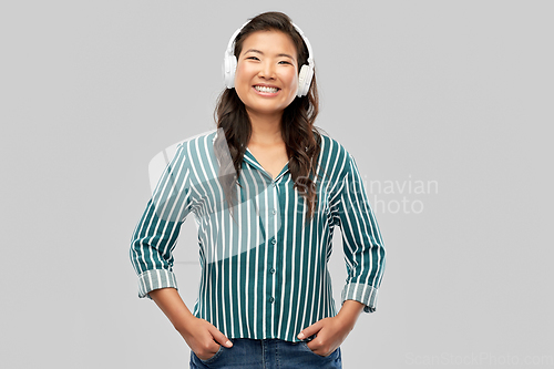 Image of asian woman in headphones listening to music