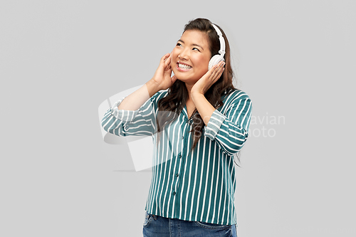 Image of asian woman in headphones listening to music