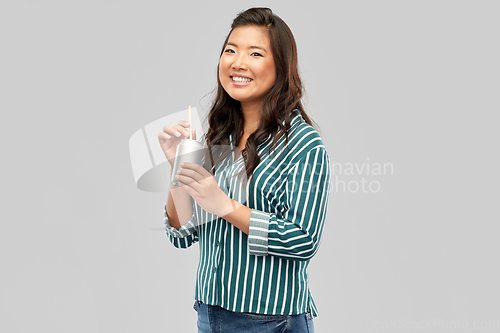 Image of happy smiling asian woman with can drink