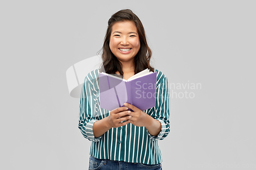 Image of happy asian woman reading book