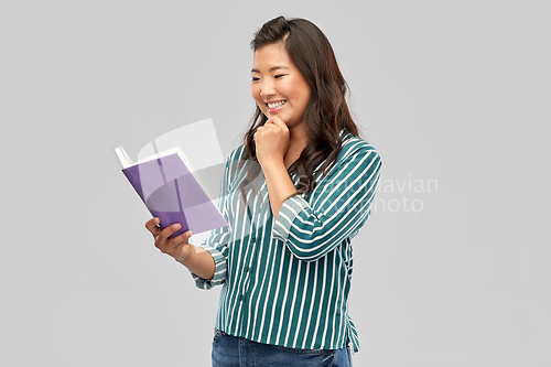 Image of happy asian woman reading book