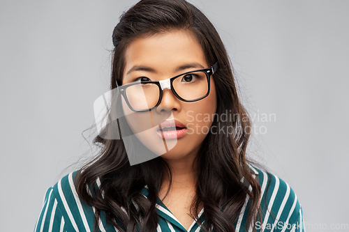 Image of portrait of confused asian woman in glasses