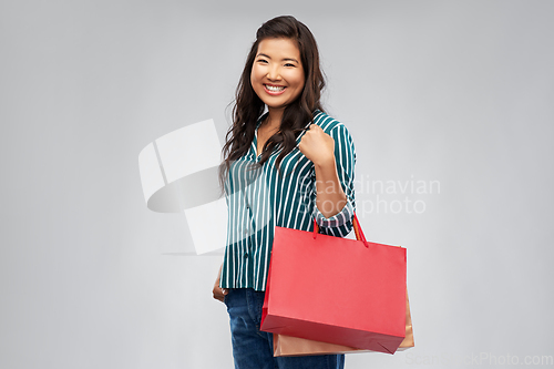 Image of happy asian woman with shopping bags