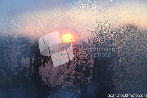 Image of Ice pattern and water drops on glass on a sunny winter morning