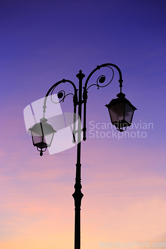 Image of Beautiful vintage street lamp against a bright sunrise sky