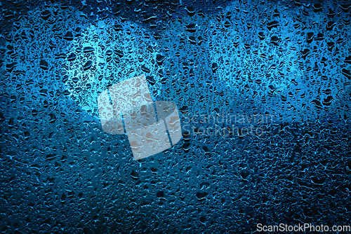 Image of Blue bokeh lights behind a wet window