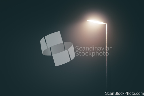 Image of Streetlight post with bright light in a misty fog