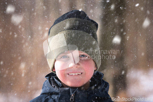 Image of Young boy in the snow with a knitted hat