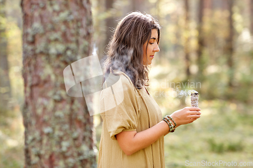 Image of woman or witch performing magic ritual in forest