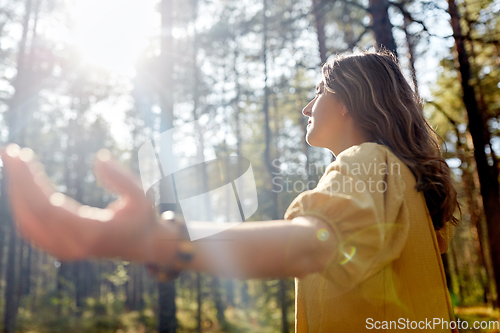 Image of woman or witch performing magic ritual in forest