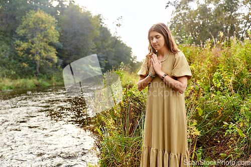 Image of woman or witch performing magic ritual on river