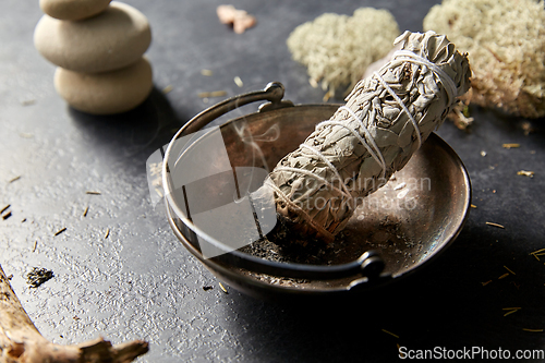 Image of smoking white sage in cup and other magic staff