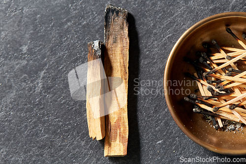 Image of palo santo sticks and cup with burnt matches