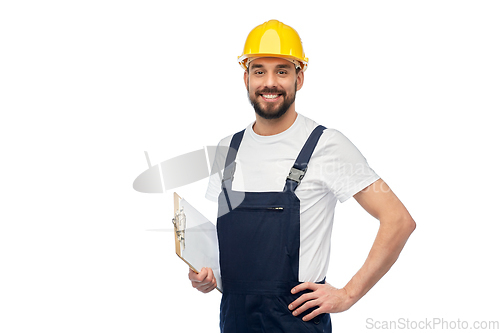 Image of happy worker or builder in helmet with clipboard