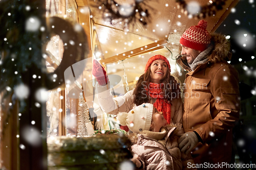 Image of happy family at christmas market in city