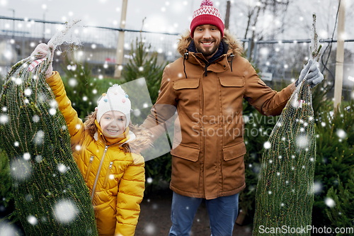 Image of happy family buying christmas tree at market