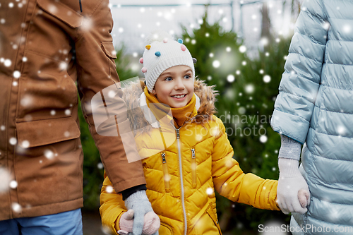 Image of happy family choosing christmas tree at market