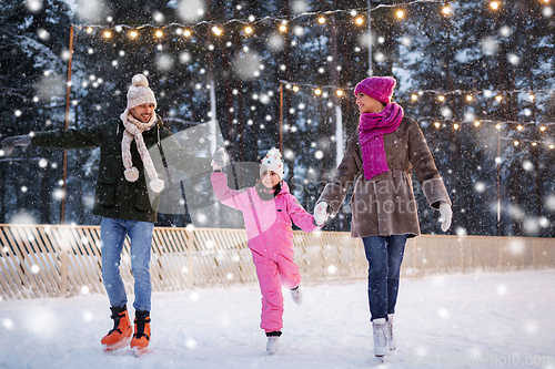 Image of happy family at outdoor skating rink in winter