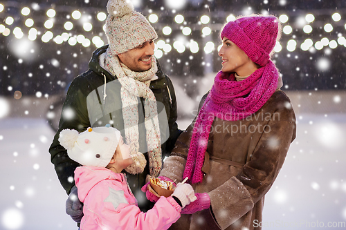 Image of happy family eating pancakes on skating rink