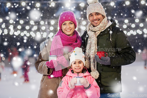 Image of happy family drinking hot tea on skating rink