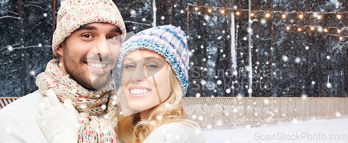 Image of happy couple hugging on outdoor ice skating rink