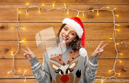 Image of woman in christmas sweater showing peace sign